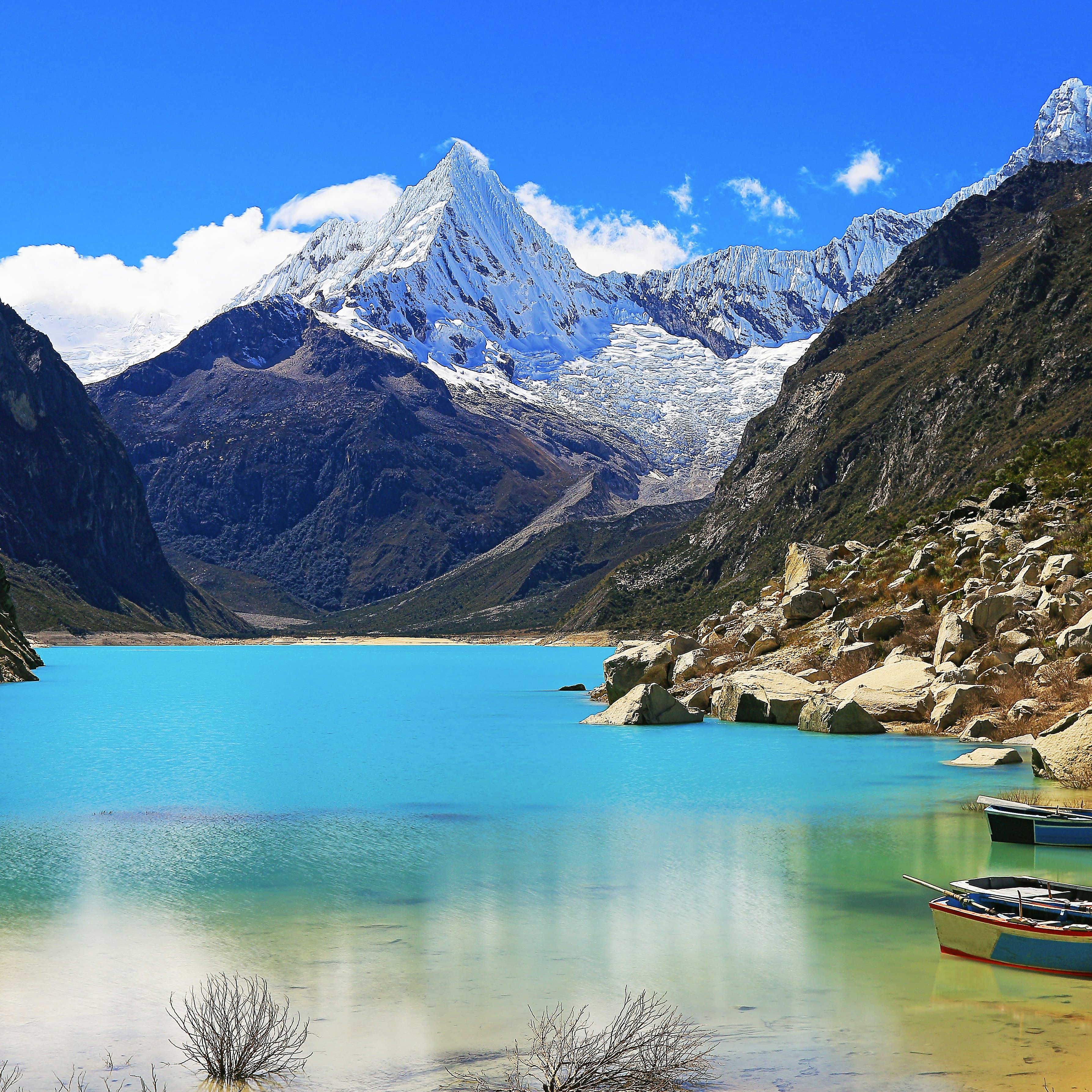 Wooden boats anchored on Paron lake in Cordillera Blanca.