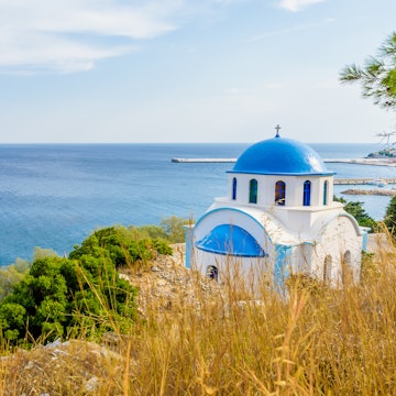 Blue and white Greek church of Agios Kirykos, situated on the rocky coast of Ikaria Island.